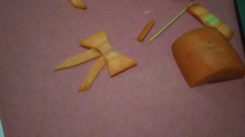 花环沙拉🌸,拿一个干净胡萝卜,我们来制作蝴蝶结🎀,手法生疏的小伙伴可以先用牙签在胡萝卜上画出蝴蝶结的形状。记得选较粗的那一段哦。