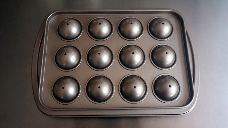 不一样的元宵，球形小蛋糕,盖上模具的另一面，放入上下火170度预热好的烤箱中层，烤20分钟。
