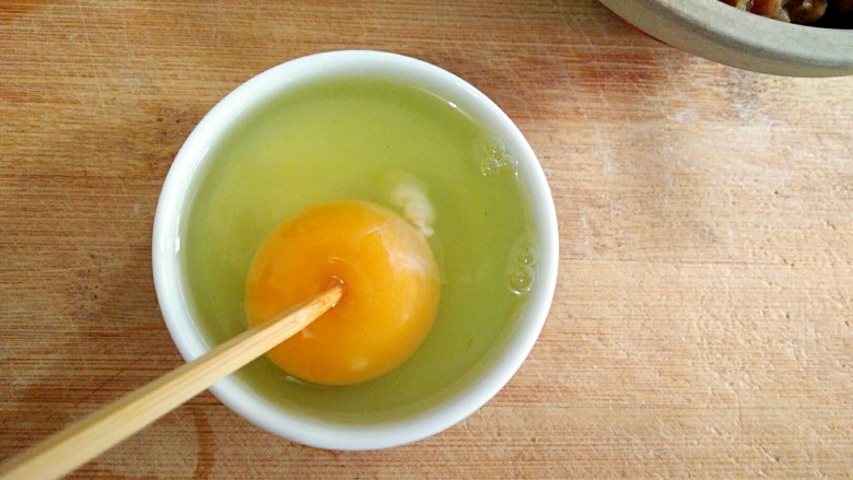 蛋满灌,将鸡蛋打入容器中，（容器尽量小点便于操作）用筷子在上面轻轻戳破蛋黄内膜。（筷子可以选择日式那种头比较尖的）
