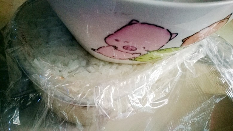 传统甜品~糯米切糕,用保鲜膜将保鲜盒盖好 用碗底将糯米压实了