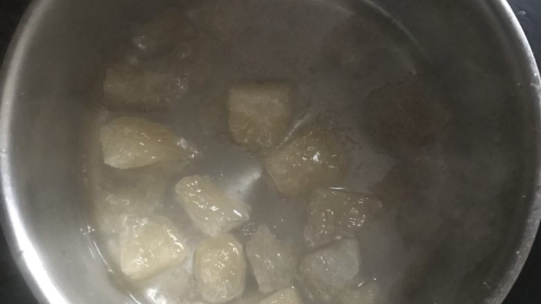 老冰糖橙皮丁,奶锅里先放大约80克水小火把冰糖化开一些,因为冰糖比较大,细小的就不用化开