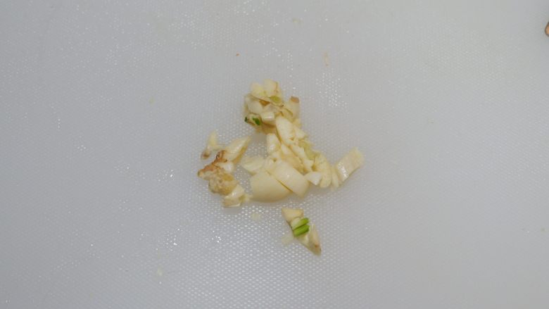 红白豆腐炖肉末,蒜去皮,用刀背拍散切末。