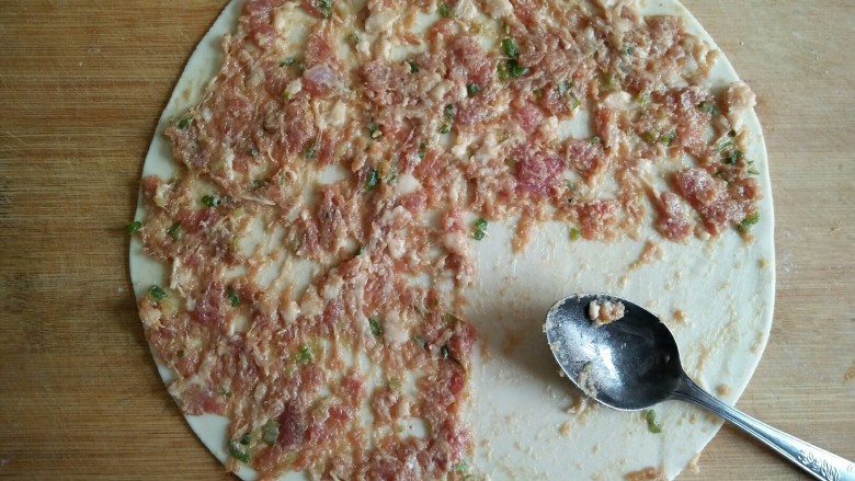 京东肉饼,用勺子背均匀涂一层肉馅,留四分之一圆不涂。