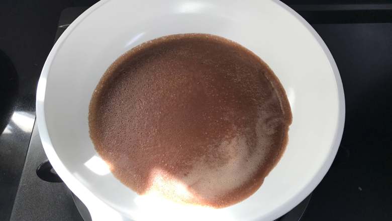 可可毛巾卷,取一不粘平底锅,倒入1勺面糊,让面糊均匀地铺满锅底。
