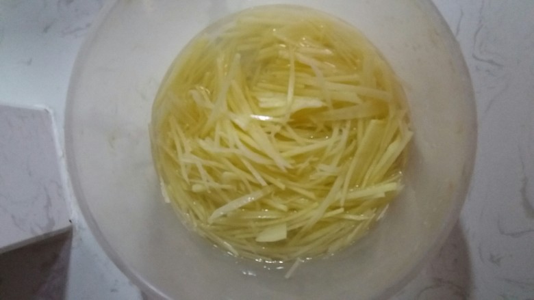 宅也要吃土豆丝,切丝状,清洗去除土豆含有的淀粉。
