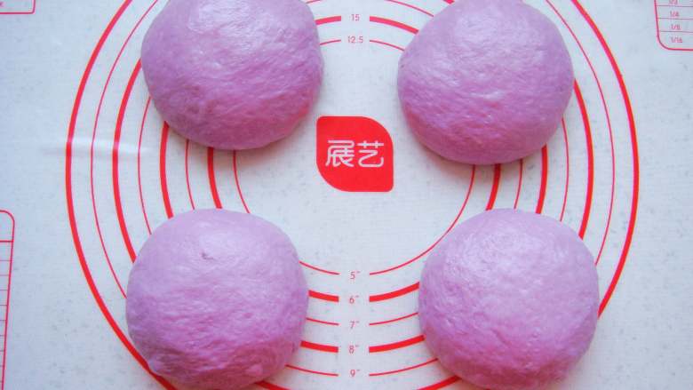 紫薯葡萄干欧包,面团放在垫子上,平均分成4份稍微揉圆。