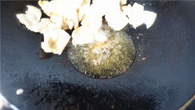 辣白菜生爆回锅肉,爆炒至肉片大量出油,用锅铲将爆好的肉片推到一边。