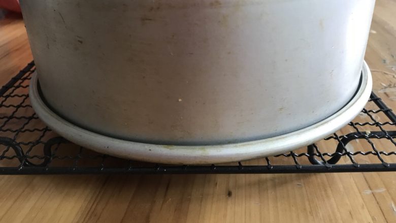 戚风蛋糕(后蛋法),把蛋糕放进烤箱,150℃烤30分钟后调170℃烤30分钟,出炉后轻摔一下震出热气,然后倒扣到晾网上晾凉。