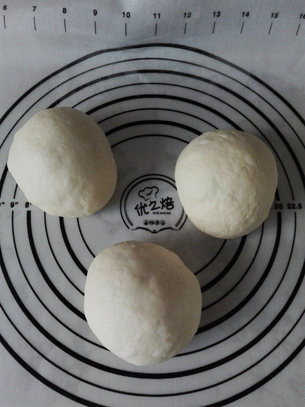 牛奶吐司,取出发酵后的面团,按压排气,分割为均等的3份,滚圆,盖保鲜膜醒发20分钟