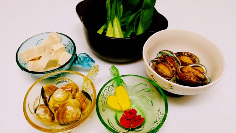 鲍鱼青蛾豆腐汤,食材准备好:<a style='color:red;display:inline-block;' href='/shicai/ 465'>豆腐</a>切小块,青蛾吐沙洗净,<a style='color:red;display:inline-block;' href='/shicai/ 250'>蟹味菇</a>用盐浸泡,哈哈小糊涂虫忘记拍了,😂😂😂😂鲍鱼鲍鱼其实很脏的,洗的时候要用刷子把鲍鱼的缝隙、裙边什么的都要刷一次,内脏在底部小心去除,鲍鱼壳也刷干净,不要扔了,这是很好的药材,所以我处理好后又装进去,