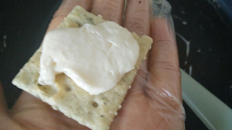 海苔牛扎饼,取一片饼干,戳一点牛扎糖放在饼干上
