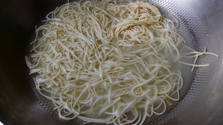 凉拌百叶,倒入切好的百叶丝,用筷子滑散,然后捞出。