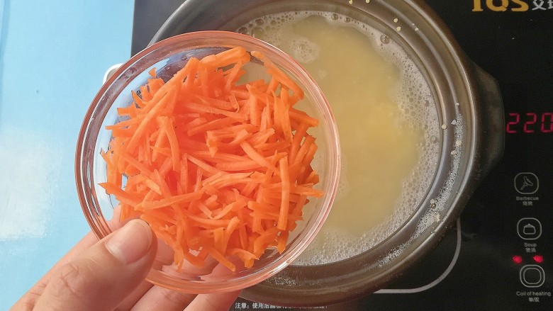 胡萝卜土豆双米粥,加入胡萝卜丝,加入两滴黑芝麻牛油果油熬煮至粘稠关火出锅
