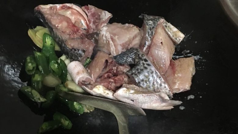 酸菜鱼,中火放鱼骨下去翻炒,加点花生油,炒一会儿
