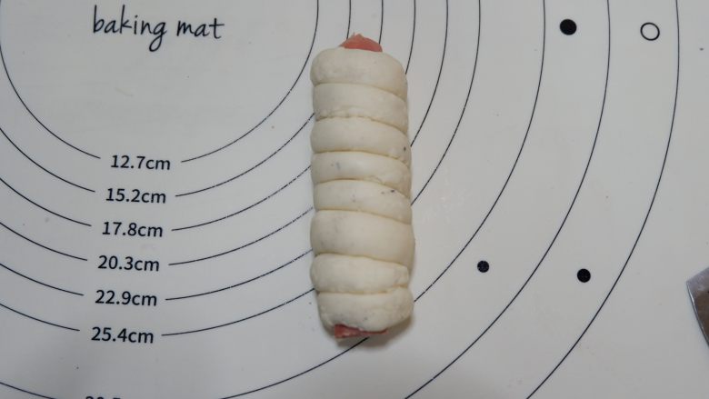 香肠卷面包,取一根香肠从头到尾缠绕起来。依次做好放入烤盘发酵至1.5-2倍大即可。