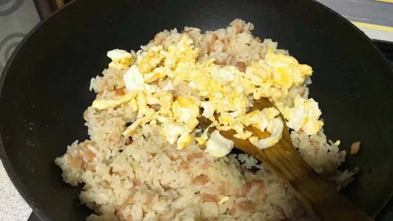 三油儿炒饭,倒入炒好的鸡蛋,翻炒一会儿。