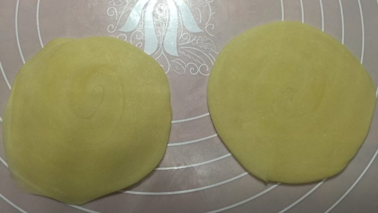 香蕉酥,用手按一下,然后用擀面杖擀成中间厚周边薄的圆片,擀的时候注意观察,圈纹的中心要在面皮的中心