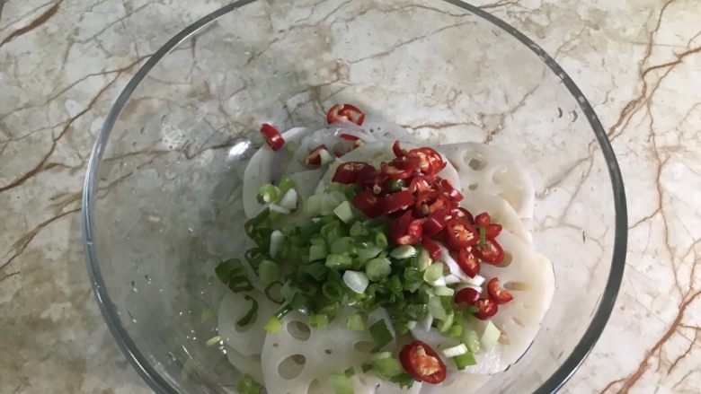 炝拌藕片,藕片沥去水分放盆中,辅料放在上面