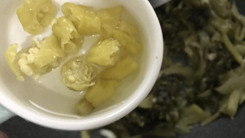 酸菜鱼(家庭微辣版),泡椒加点泡椒水倒入锅里翻炒。