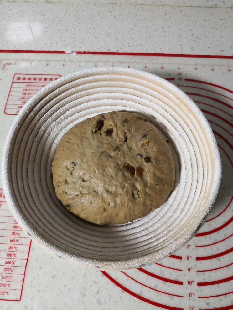 全麦红糖桂圆核桃软欧包,面团发酵好之后取出,排气滚圆,放入藤篮中,记得收口朝上。