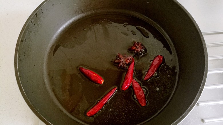 红烧豆腐角,炒锅里放适量油,放入大料和干辣椒略炸出香味。