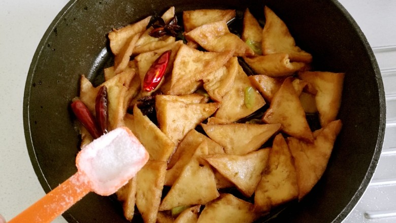 红烧豆腐角,等到汤汁收浓稠时,加入适量的盐。