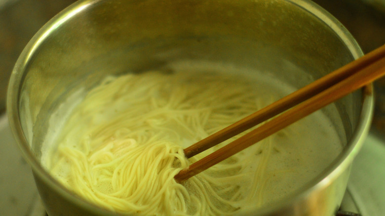 芝香菌菇拌面,锅里烧开水,放面条下去煮,一边煮一边用筷子拨动,以免粘连