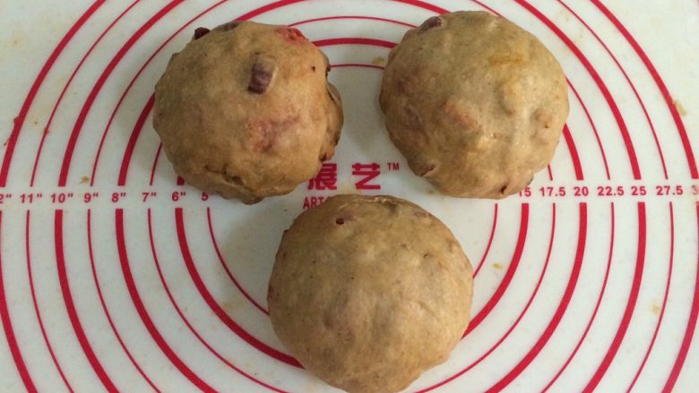 红枣枸杞软欧包,取出面团进行排气,平均分成三份,滚圆松弛15分钟,记得盖上保鲜膜。