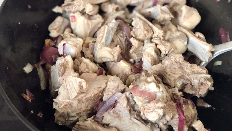 新疆抓饭,放入羊排继续煸炒至炒面金黄;
