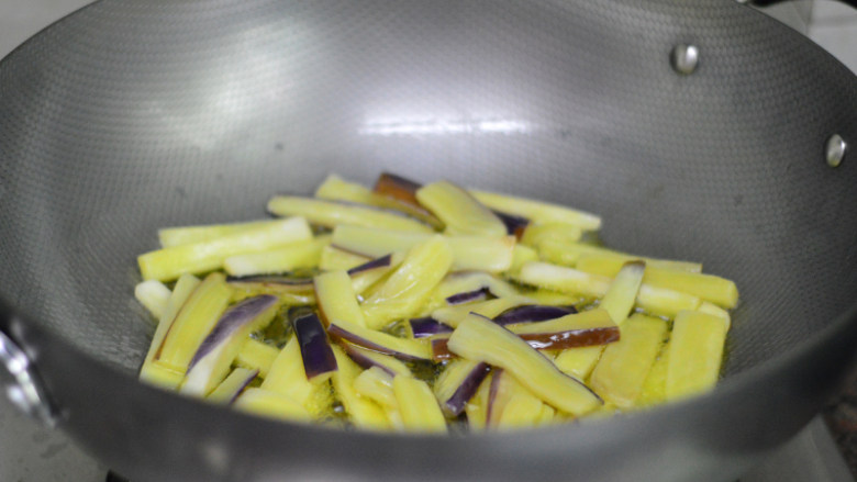 辣酱烧茄子,炒至茄子软熟后捞出,控干油份