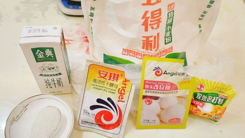 牛奶夹糖白馒头,普通面粉,纯牛奶(可以换成水),白糖适量(可以不放),酵母(必须要),馒头改良剂(可以不放),泡打粉(可以不放),我做的是牛奶加糖的香甜馒头,如果喜欢吃原味的,可以参照括号里面的,只放面粉+水+酵母,那酵母放5g,面粉和酵母一般100:1,我放了泡打粉,所以酵母少放了点。