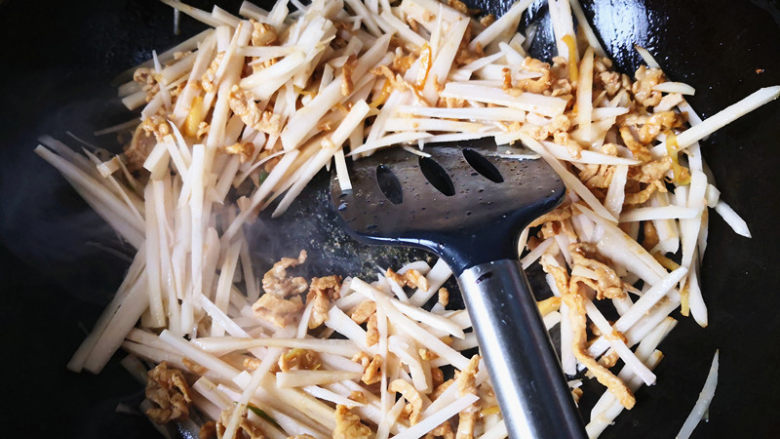 藕丝炒肉丝,炒均匀后，把藕丝从水里捞出来，倒入锅中，不断翻炒，