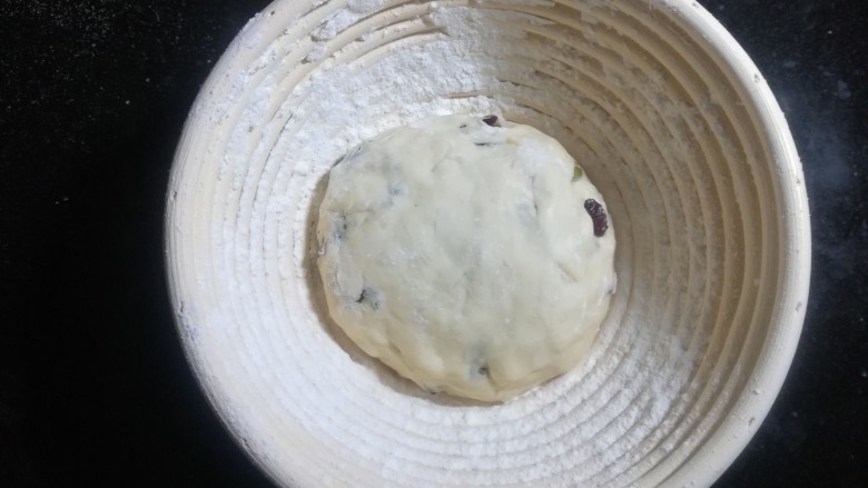 果仁欧包,用面粉筛在发酵篮里,撒上薄薄的一层粉。把揉好的面团放入,光滑的那一面向下,收口面向上。发酵至两倍大。