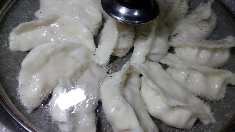 鲜肉锅贴,盖上锅盖,中火煎制两三分钟。再倒半碗水,中小火煎两三分钟。也可以一次性多倒一些水,不要超过饺子的一半高。