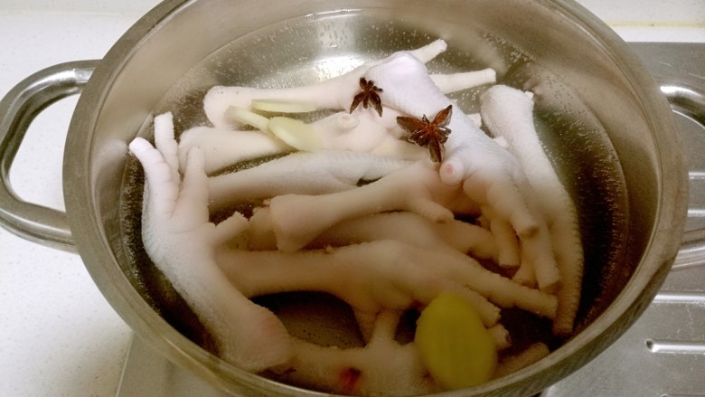韩式辣酱鸡爪,锅中放入凉水,放入鸡爪加入一个八角,几片姜片。