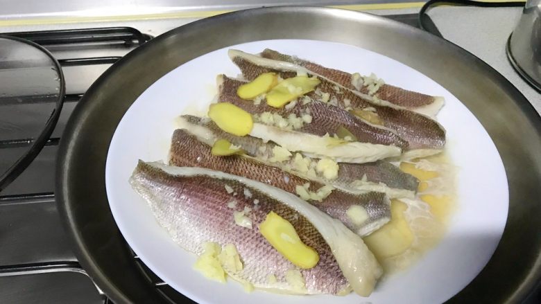 馋嘴版家庭烤鱼,蒸好的鱼,把姜片取下来,汤可以倒掉。