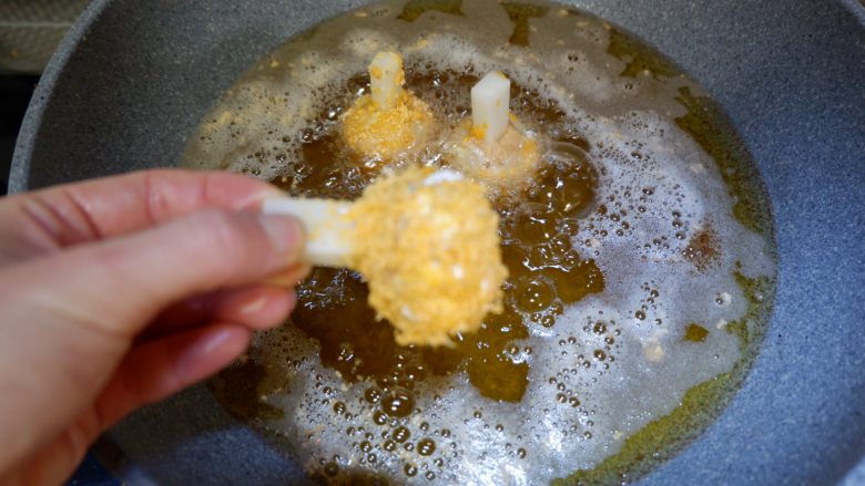完美便当方程式「14」,拿着年糕,没有鸡肉的一头,先蘸一下干淀粉,在粘满蛋液,最后裹粘满面包糠,然后放入热好的油锅里