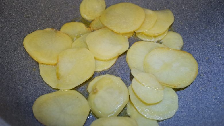 完美便当方程式「16」,锅内倒入食用油,烧至八成热,倒入土豆片煎至一会,煎至基本断生