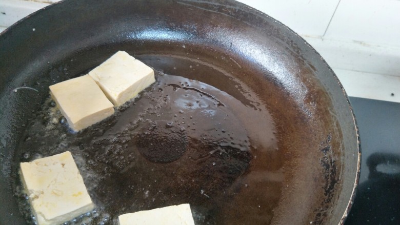 椒盐煎豆腐,待油温六七成热,把豆腐放入平底锅中。