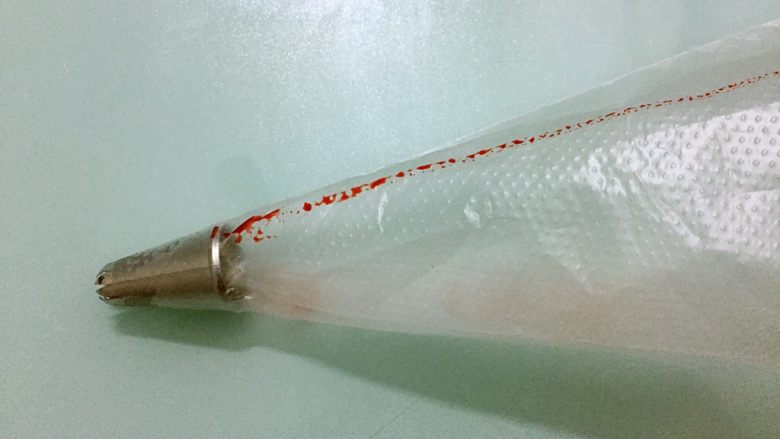 双色蛋白糖,裱花袋装入裱花嘴,再用翻糖笔沾上色素在裱花袋里画上直线,如图