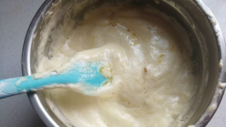 蔓越莓橙香海绵蛋糕,再把橙汁混合液也分两次淋在搅拌刀上,让橙汁液自然地流在蛋糊表面,然后切拌均匀