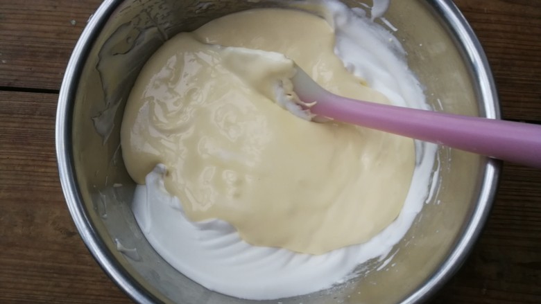 轻乳酪蛋糕,翻拌好的面糊全部倒入剩余的蛋白霜中,用刮刀翻拌均匀