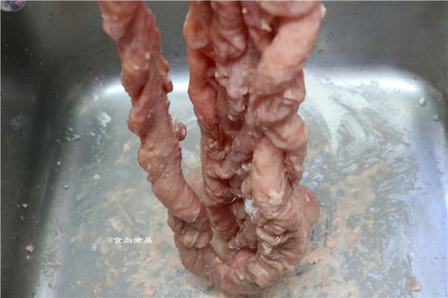 糯米酿猪大肠,揉至猪大肠吸收了面粉,再倒一些面粉继续搓揉,手法像洗衣服一样