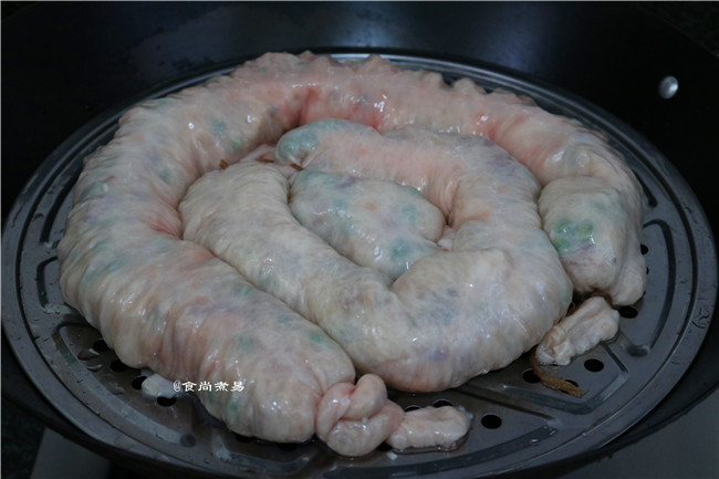 糯米酿猪大肠,蒸锅里放入适量清水,将酿好的大肠放入锅中的蒸笼里或蒸架上