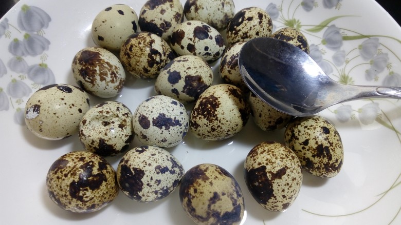 辣味卤鹌鹑蛋,用勺子把鹌鹑蛋的表面敲出裂纹,以利入味,蛋的表面要调得均匀一些,每个地方都敲到。