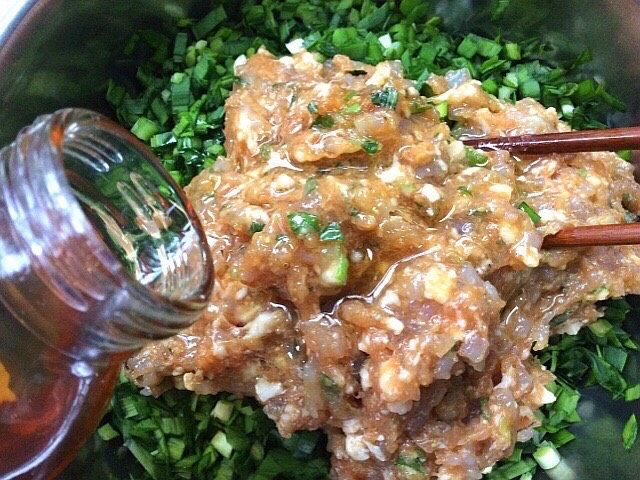 韭菜虾肉锅贴,韭菜切碎把拌好的虾肉放入,倒入熟油搅拌均匀