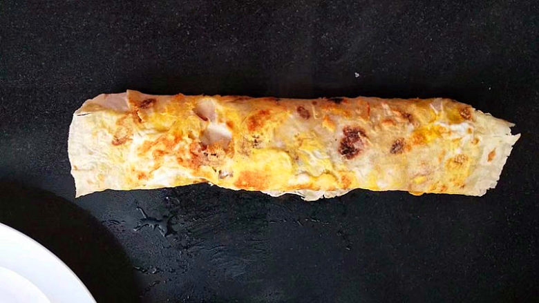 早餐鸡蛋饼,慢慢卷起，把鸡蛋那一面向外