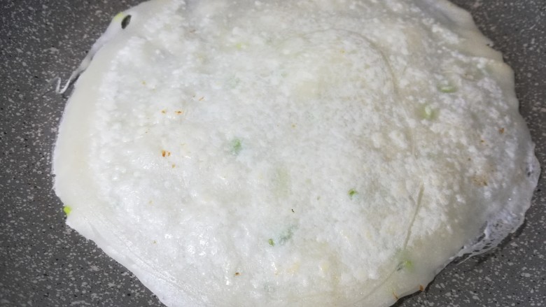 双色鲜味菠菜卷,翻一个面继续加热,只有小气泡,颜色变微黄,就可以盛到盘子里。
