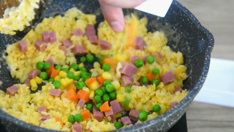 吃货们的福音—黄金什锦蛋炒饭,原来好吃的炒饭是这么做出来的,倒入火腿丁、杂菜继续翻炒。