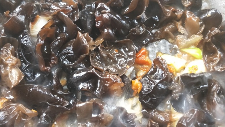 营养黄花菜木耳炒肉,倒入沥干水的木耳,翻炒均匀。